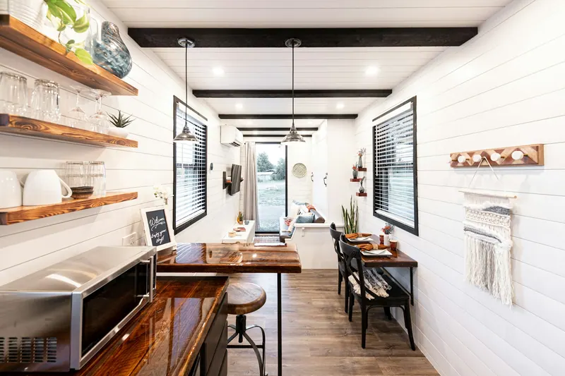 Inside a small home: kitchen, open shelves and a dining counter