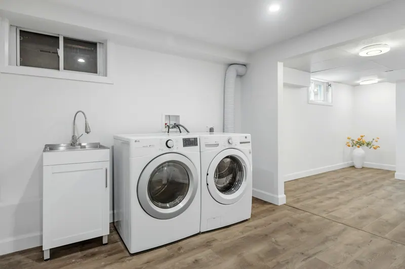 Basement laundry room with a utility sink, washer and dryer