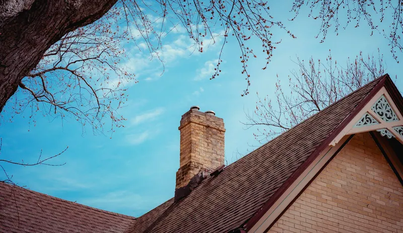 Brick chimney rising above a pitched roof