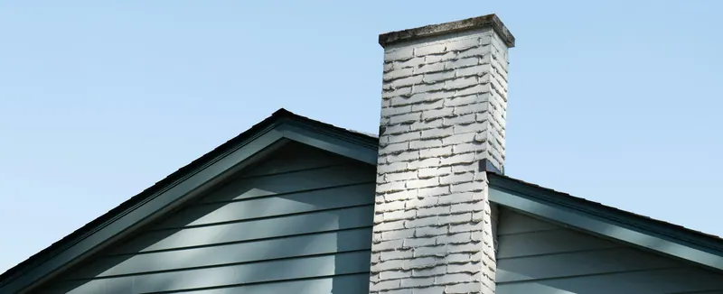 Painted brick chimney above a gable roof