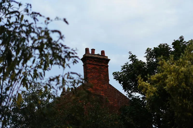 Red brick chimney stack above the trees