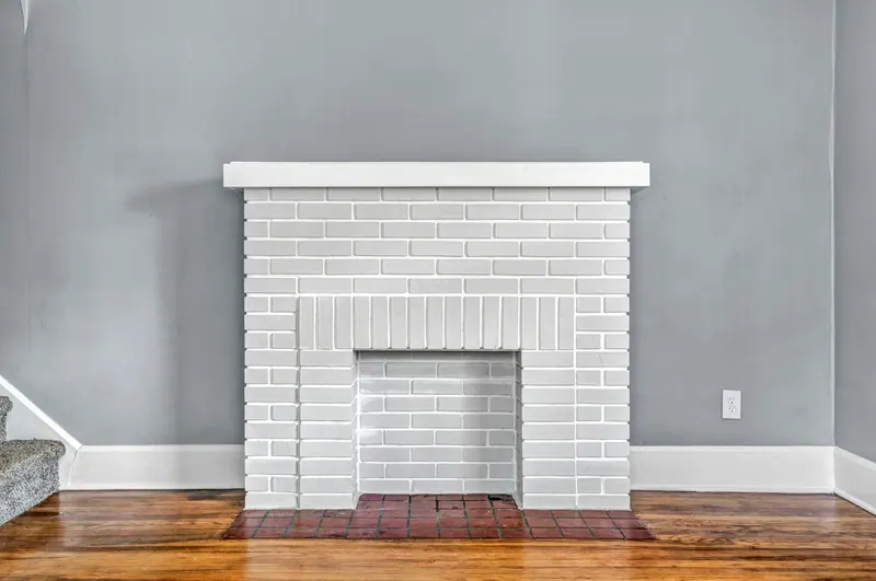 White brick fireplace against a gray wall