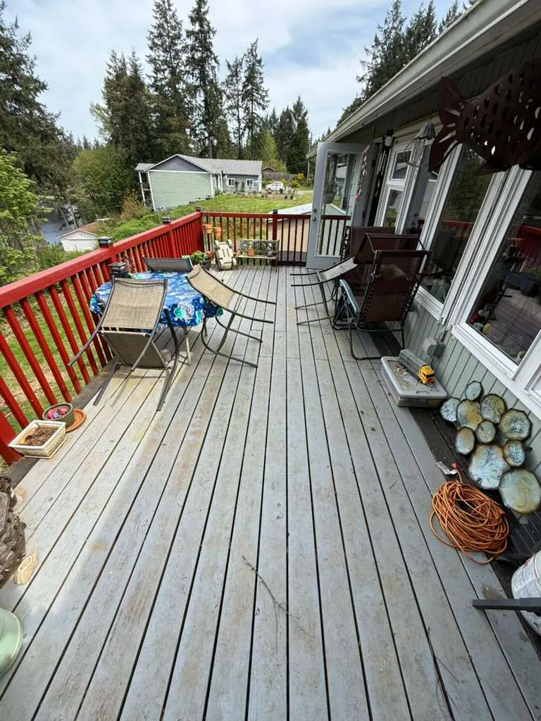 Before: The deck before the replacement, with weathered wood boards and red wood railings