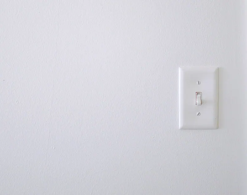 White toggle light switch on a white wall