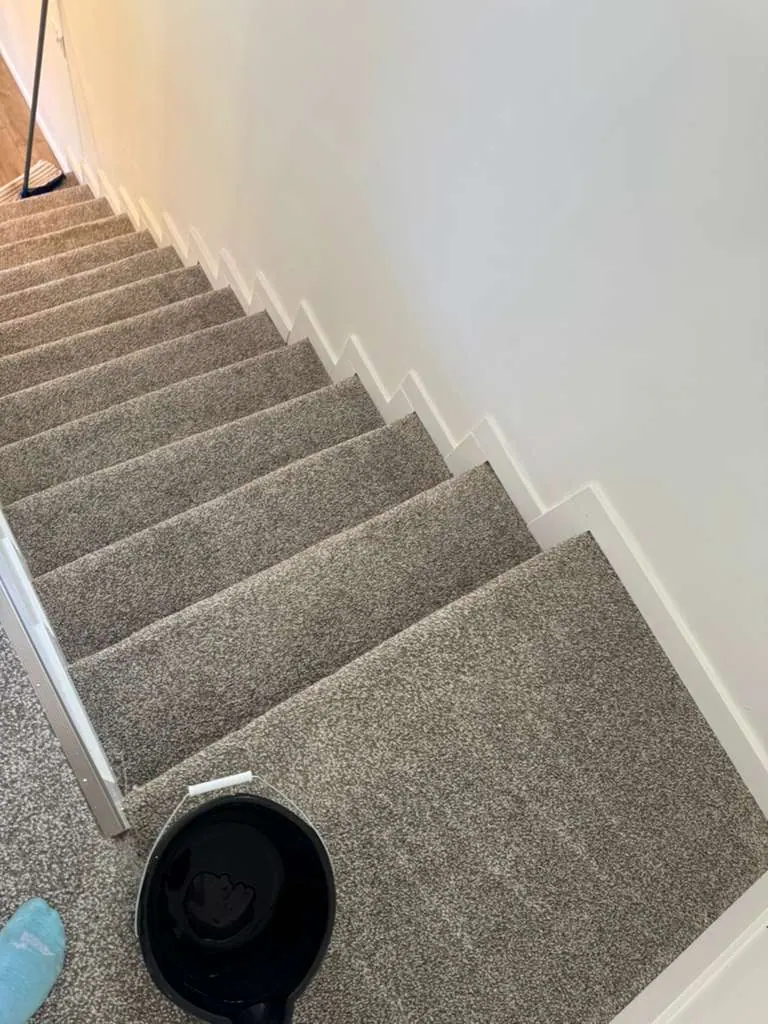New gray carpet on a staircase and landing with white trim