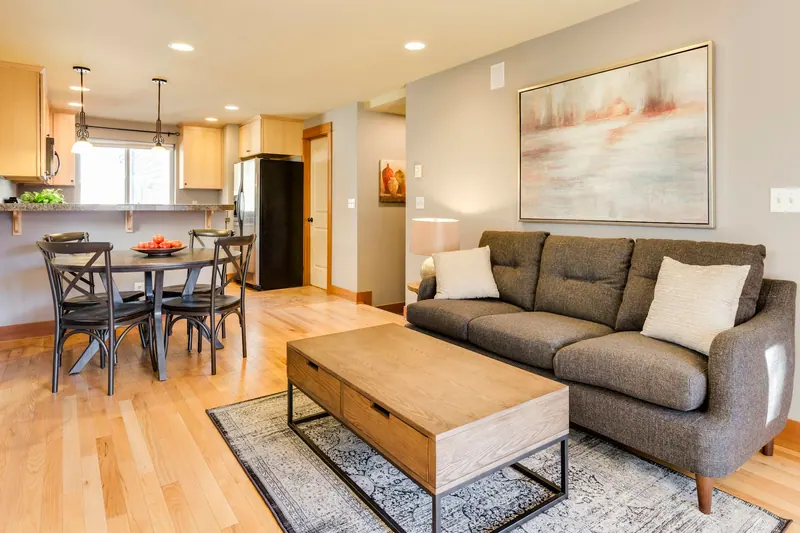 Renovated open living and dining area with wood floors