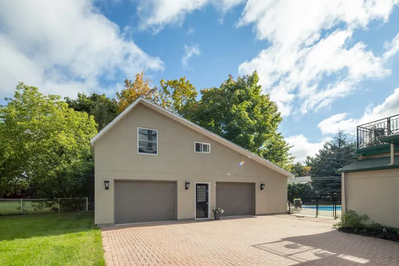 Detached two-door garage with a paver driveway