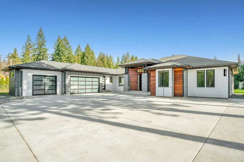 Single-story house with a long driveway and wide garage doors