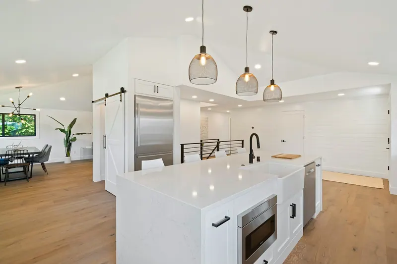 Renovated white kitchen with an island and pendant lights