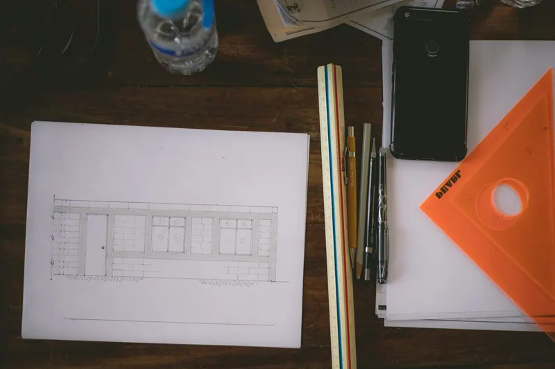 Drawing sheet with pencils and drafting tools on a desk