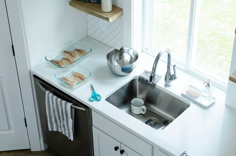 Kitchen sink and faucet under a window
