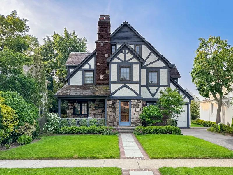 Tudor-style house with a front lawn and a stone walkway