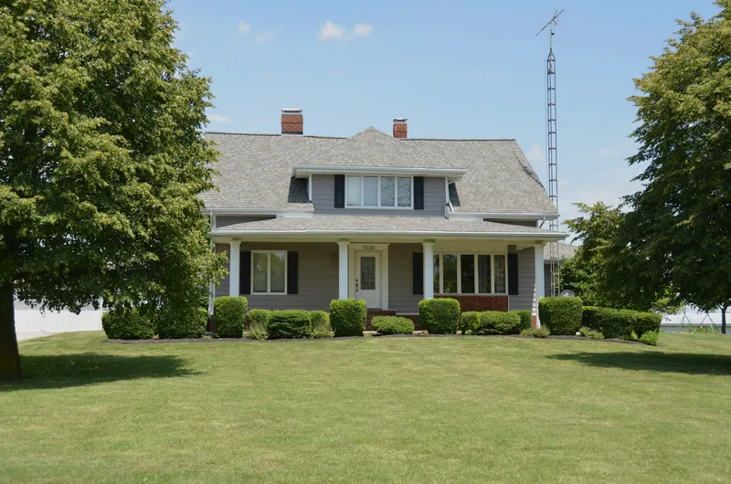 Traditional gray house with a wide porch and a lawn