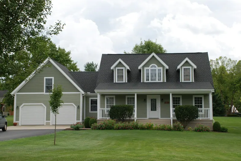 Cape Cod-style house with sage siding and a front porch